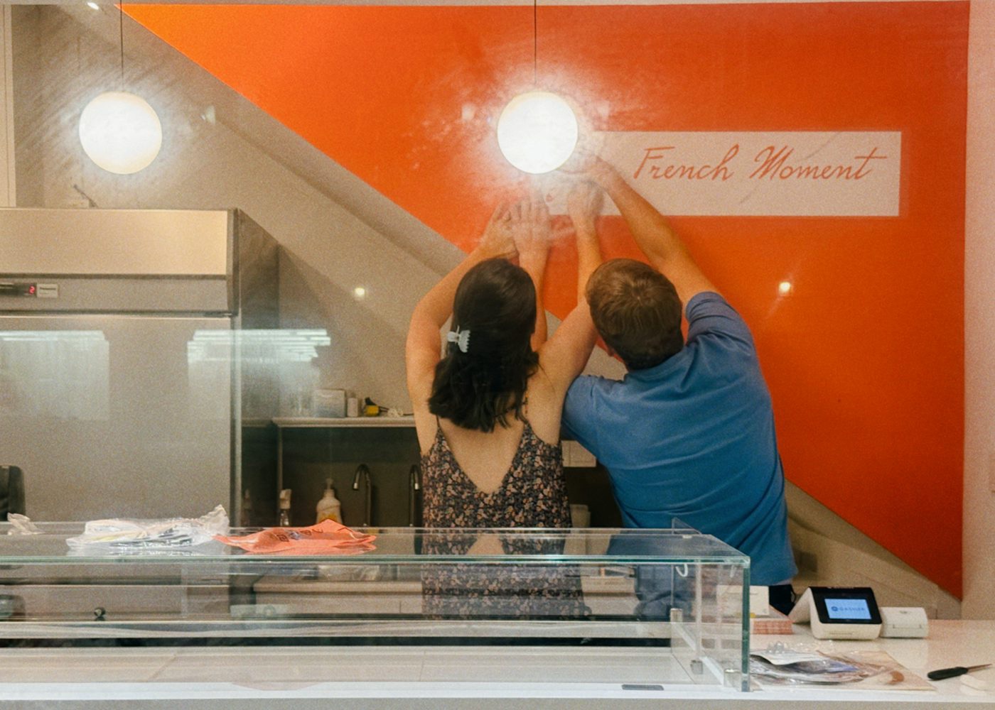Owners hanging a sign in their restaurant